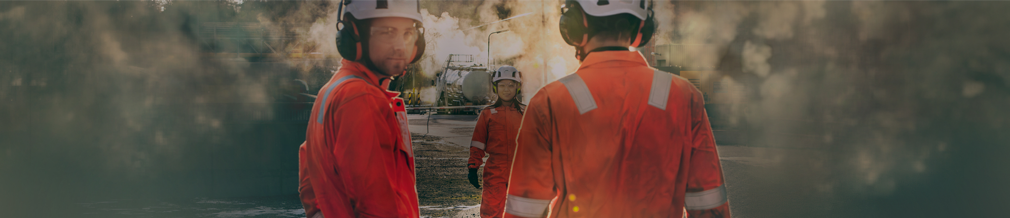 Workers in protective gear at an industrial site